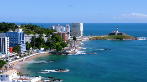 Aerial-view-of-Santa-Maria-Fort,-the-beach,-the-neighborhood,-some-boats-parked-and-the-Farol-da-Barra-at-background,-Salvador,-Bahia,-Brazil