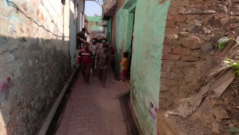 Toma-En-Primera-Persona-En-Muchos-Callejones-Pequeños-De-Nadagaoan.-Los-Niños-Pequeños-Están-Volando-Con-Gran-éxito-Ante-Diferentes-Personas-De-Pichkari-Y-La-Gente-Camina-Hacia-El-Templo.