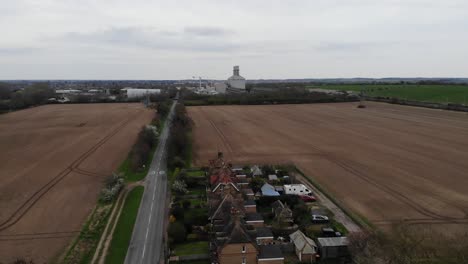 Aufsteigende-Drohnenaufnahme-Mit-Feldern-Und-Dem-Kraftwerk-Little-Barford-Im-Hintergrund