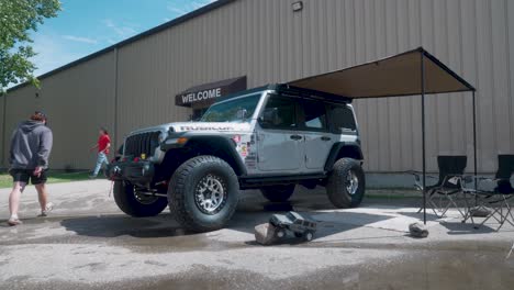 Die-Kamera-Bewegt-Sich-Von-Einem-Kleinen-Silbernen-Ferngesteuerten-Spielzeug-Jeep-Zu-Einem-Identischen-Echten-4x4-Offroad-Fahrzeug-Bei-Einer-Autoshow