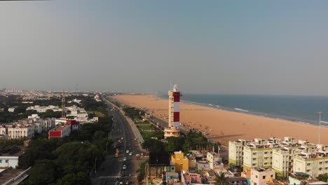 Aerial-View-Of-Chennai-Marina-Lighthouse-Beside-Coastal-Beach-In-India