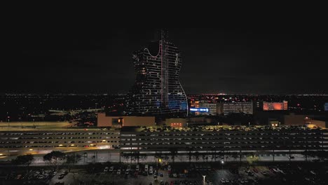 An-aerial-view-of-the-guitar-shaped-Seminole-Hard-Rock-Hotel-and-Casino-structure-illuminated-with-lights-on-at-night