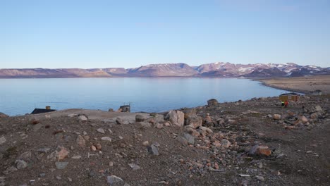 Coast-of-Greenland-on-Sunny-Spring-Day,-Cape-Tobin-Huts-and-Shelters-in-Landscape