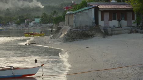 Tropical-beach-in-the-Philippines-with-a-local-child-swimming-in-the-sea-and-smokey-mountain-background