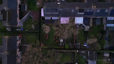 Top-down-view-on-Dutch-suburb-with-rooftop,-houses-solar-panels-and-streets