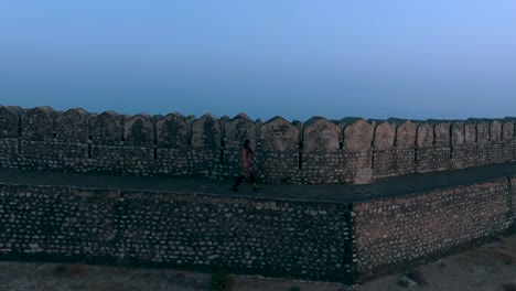 Vista-Aérea-De-Una-Persona-Caminando-A-Lo-Largo-Del-Muro-De-Defensa-En-El-Fuerte-Ranikot.