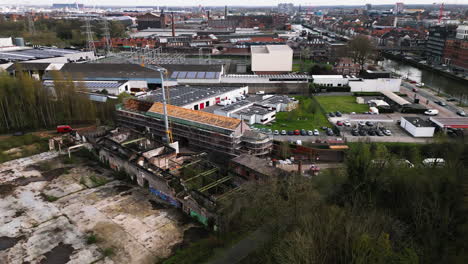 Modern-cityscape-of-Ghent-and-abandoned-building,-aerial-orbit-view