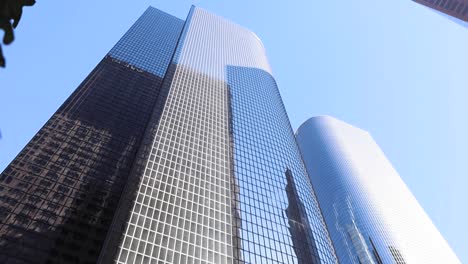 Slow-pan-down-of-a-skyscraper-through-tree-leaves