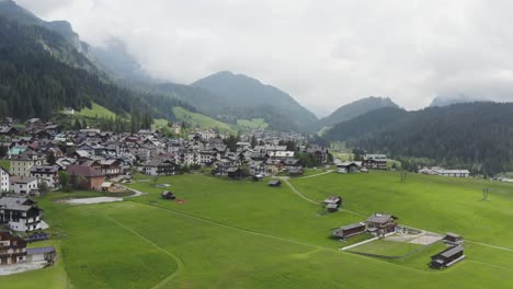 Summer-meadows-and-mountains-surround-Sappada,-Italian-Dolomites-ski-resort,-Aerial
