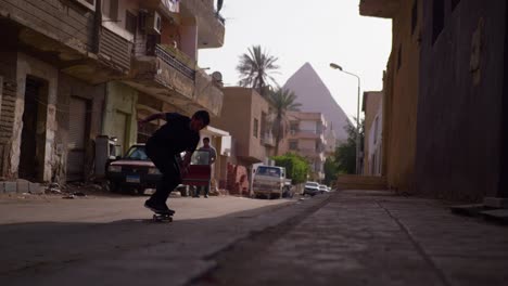 Mann-Macht-Einen-Skateboard-Trick-Mit-Den-Pyramiden-Von-Gizeh-Im-Hintergrund