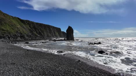 Full-tides-at-Ballydwane-Beach-with-impressive-sea-stack-and-cliffs-on-a-spring-day