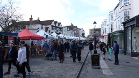 People-visiting-and-shopping-at-popular-Wells-Market-Place-on-historic-cobbled-streets-on-Easter-Weekend-in-Southwest-of-England-UK