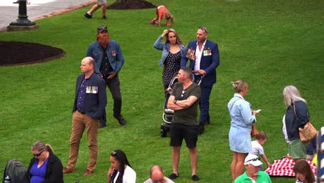 Australian-military-serviceman-and-his-family-walking-across-the-lawn-of-Anzac-Square,-prior-to-the-annual-Anzac-Day-parade-tradition