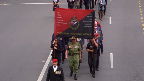 Representatives-from-the-Military-Police-Association-of-Australia-walking-down-the-street-during-annual-Anzac-Day-parade,-paying-tribute-to-war-heroes,-close-up-shot