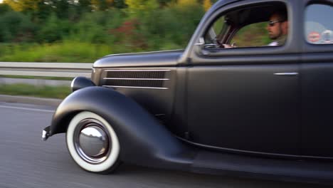 Un-Coche-Antiguo-Negro-Circula-Por-Una-Carretera-Hacia-Un-Puente.