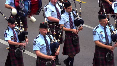 Queensland-Police-Pipes-and-Drums,-pipers-and-drummers,-playing-bagpipes-and-drums-for-Brisbane-City-during-the-annual-tradition-of-Anzac-Day-parade,-close-up-shot