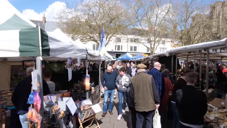 Menschen-Besuchen-Und-Kaufen-An-Marktständen-Lokaler-Unternehmen-In-Engen-Gassen-Auf-Dem-Marktplatz-Von-Wells-über-Das-Osterwochenende-Im-Südwesten-Von-England,-Großbritannien