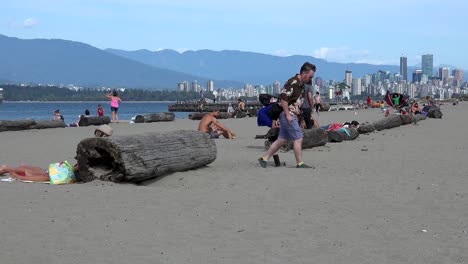 Skyline-of-Vancouver-and-cityscape-from-Locarno-beach-with-multi-walkers-and-Stanley-Park-in-background