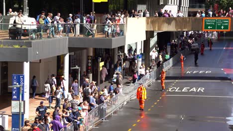 Menschen-Versammeln-Sich-Entlang-Der-Adelaide-Street-Mit-Freiwilligen-Des-Queensland-State-Emergency-Service,-Die-Bei-Der-Kontrolle-Der-Menschenmenge-Bei-Der-Jährlichen-Anzac-Day-Parade-Helfen-Und-Für-Sicherheit-Und-Ordnung-In-Der-Öffentlichkeit-Sorgen