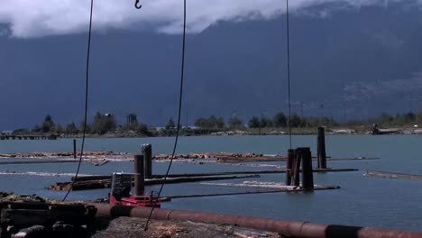 Ein-Mann-Startet-Ein-Auslegerboot-Mit-Baumstämmen-Im-Fluss