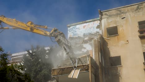 Demolition-Excavator-Tearing-Down-Building,-Creating-Dust-From-Falling-Debris