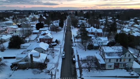 Beautiful-snow-covered-american-town-with-straight-road-at-golden-sunset