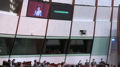 Carrie-Lam,-Ehemalige-Regierungschefin-Von-Hongkong,-Ist-Auf-Dem-Bildschirm-Des-Hauptsaals-Zu-Sehen,-Während-Sie-Im-Gebäude-Des-Legislativrats-Ihre-Jährliche-Politische-Ansprache-Hält.