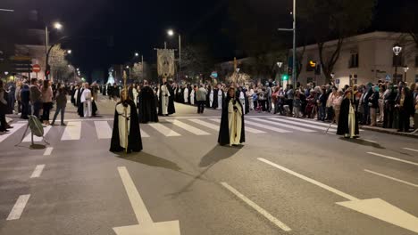 Im-Vordergrund-Ist-Die-Prozession-In-Formation-Zu-Sehen,-Gefolgt-Von-Den-Messdienern-Mit-Dem-Banner-Der-Jungfrau-Maria,-Und-Dahinter-Sehen-Wir-Einen-Gläubigen-Mit-Umhang,-Der-Die-Formation-Mit-Gesten-Koordiniert.