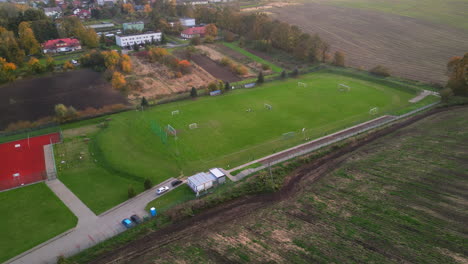 Aerial-drone-shot-of-soccer-players-engaging-in-a-football-match-on-a-field-in-Poland-during-autumn