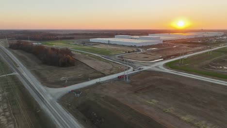 Aerial-approach-of-Ford's-Megacampus,-BlueOval-City-in-Stanton,-TN,-with-beautiful-sunset-backdrop