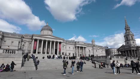 Morning-footage-captures-pedestrians-walking-towards-Trafalgar-Square-stairs-toward-London's-National-Portrait-Gallery,-a-concept-of-cultural-heritage