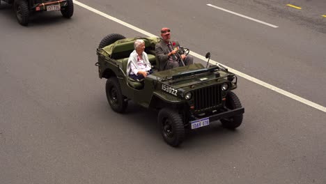 Eine-Frau-Fährt-In-Einem-Historischen-Militärfahrzeug-Die-Straße-Entlang-Und-Nimmt-An-Der-ANZAC-Day-Parade-In-Brisbane-Teil,-Zu-Ehren-Derer,-Die-Während-Des-Krieges-Gedient-Und-Opfer-Gebracht-Haben