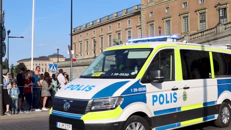 Police-van-drives-by-Royal-Palace-on-Swedish-national-day,-close-slomo