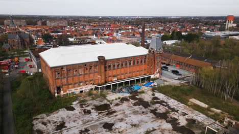 City-of-Ghent-and-abandoned-red-brick-building,-aerial-view
