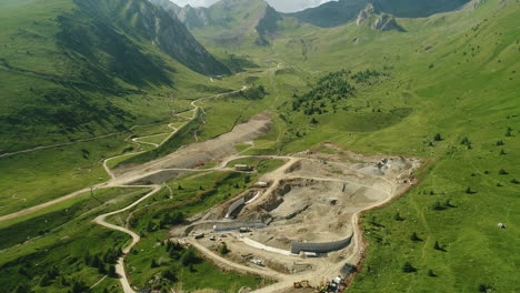 Top-down-aerial-drone-shot-of-a-dam-construction-site-in-the-alpine-mountains