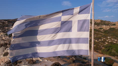 Satri,-Greece,-Greek-National-Flag-Waving-on-Pole-at-Coastline-of-Aegean-Sea