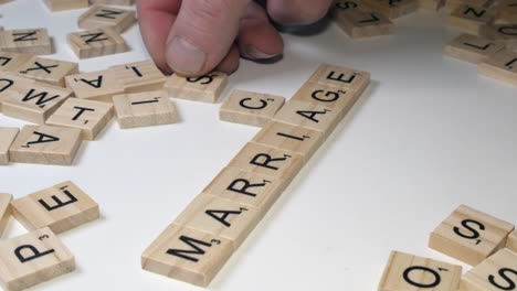 La-Mano-Derecha-Coloca-Letras-De-Mosaicos-De-Scrabble-Sobre-La-Mesa:-Estafa-Matrimonial.