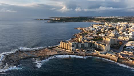 Aerial-view-of-Abandoned-Jerma-Palace-Hotel-and-l-Jerma-Bay-in-Marsaskala,-sunrise-time,-Malta