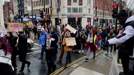 A-diverse-crowd-marched-down-a-city-street,-carrying-signs-and-banners-to-show-solidarity-with-Palestine