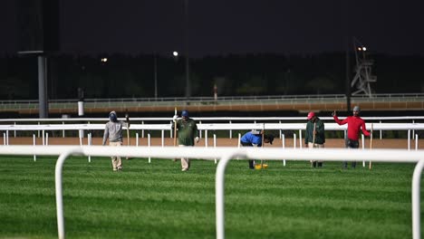 Workers-prepare-the-turf-surface-of-the-race-track,-utilized-for-horse-racing-in-the-United-Arab-Emirates