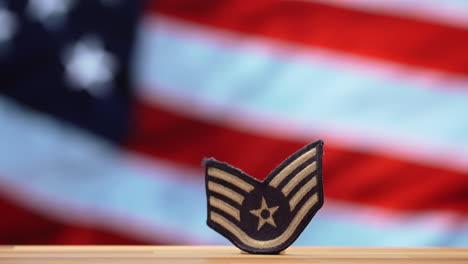 Militärischer-Patch-Der-Luftwaffe-Mit-Verschwommenem,-Wehender-Amerikanischer-Flagge-Im-Hintergrund
