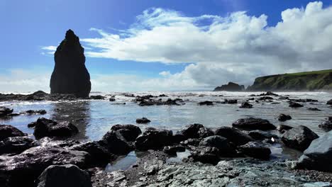 Gentle-incoming-tide-on-rocky-beach-with-beautiful-sea-stack-and-coastline-Ballydwane-Beach-in-Waterford-Ireland