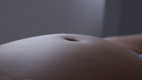 Close-up-of-a-pregnant-belly-with-baby-kicking-from-within