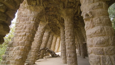 Walking-through-Park-Guell-under-a-path-of-arcades-and-stone-columns