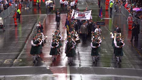 The-Queensland-Irish-Association-Pipe-Band,-dressed-in-traditional-attire,-performs-in-the-Anzac-Day-parade,-marching-down-the-street-in-Brisbane-city