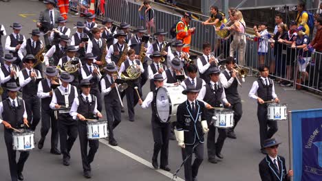 Estudiantes-De-Música-De-La-Banda-De-La-Escuela-Primaria-De-Brisbane-Interpretando-Instrumentos-Musicales,-Marchando-Por-La-Calle-En-El-Desfile-Del-Día-De-Anzac,-Rindiendo-Homenaje-A-Quienes-Sirvieron-Y-Se-Sacrificaron-Durante-La-Guerra.