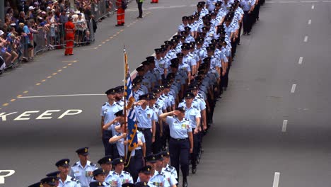 Large-group-of-disciplined-service-men-and-women-from-Royal-Australian-Air-Force-uniformly-marching-down-the-street-in-Brisbane-city,-amidst-the-solemnity-of-the-Anzac-Day-commemoration