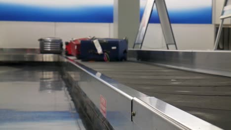 Person-picking-up-their-luggage-at-the-airport