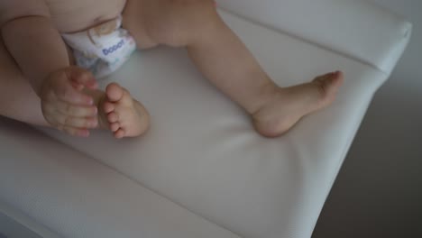 Baby-Auf-Dem-Wickeltisch-Mit-Nackten-Füßen