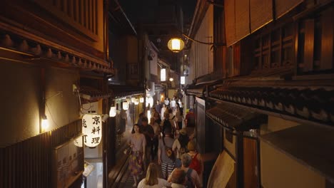 Nächtliche-Filmaufnahme-Durch-Die-überfüllte-Pontocho-Gasse,-Shijo-dori,-Mit-Traditionellen-Holzfassaden-Und-Laternen,-Die-Den-Touristisch-überfüllten-Bezirk-Nakagyo,-Kyoto,-Japan,-Beleuchten-1